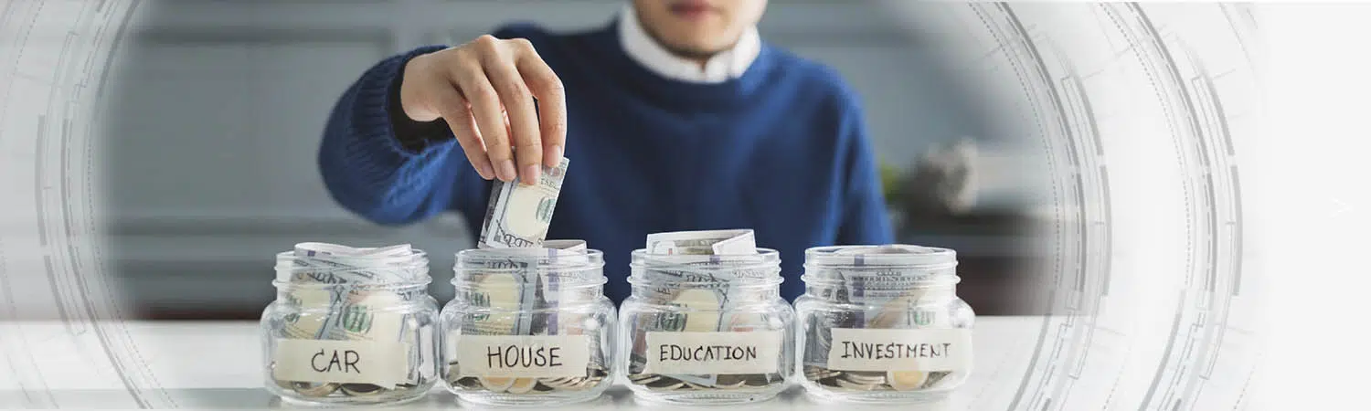 A man saving money in four glass jars